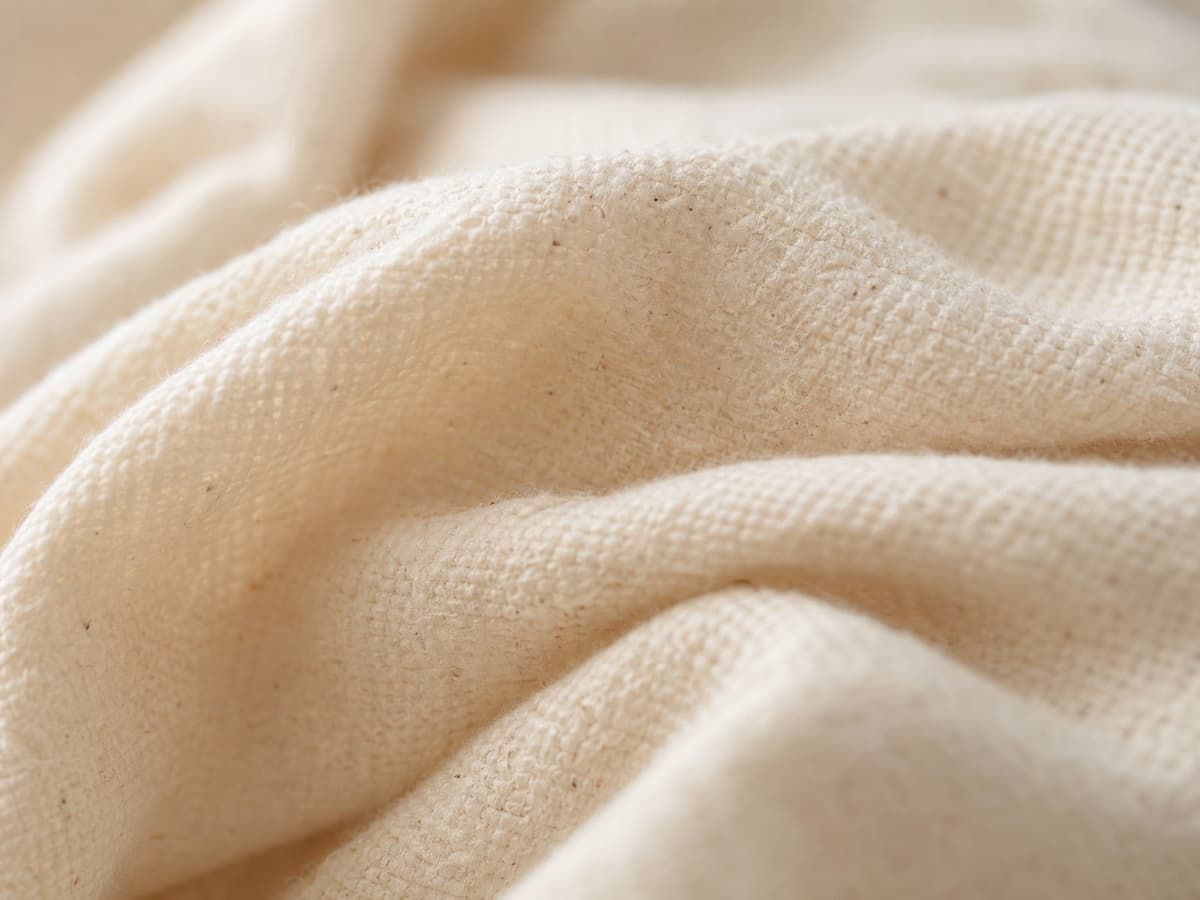 Close-up of raw, undyed organic cotton fabric texture.