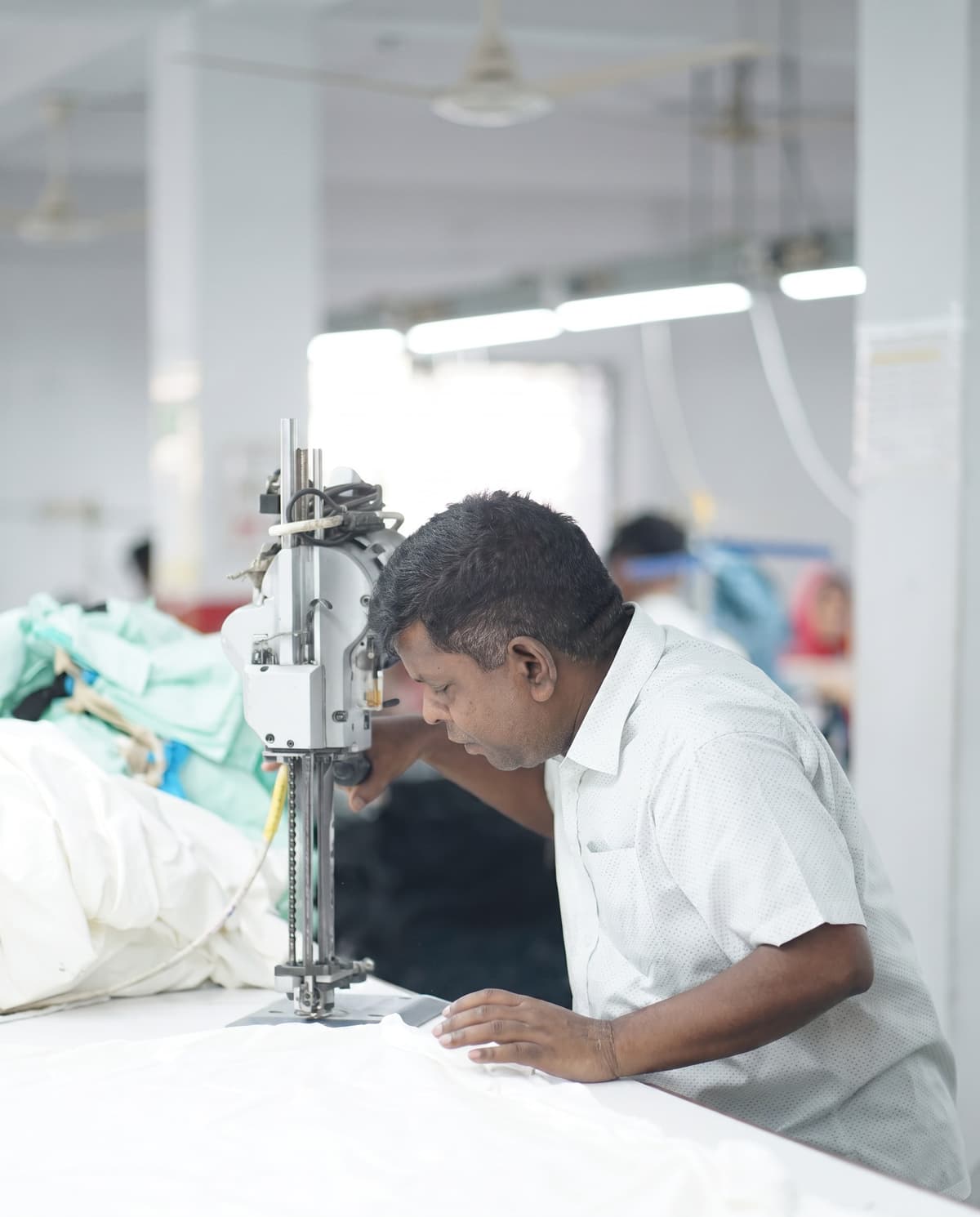 Rakib at his sewing machine on the line at the Collective Studio factory.