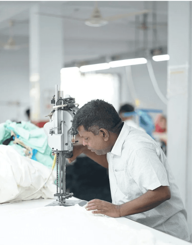 Rakib at his sewing machine on the line at the Collective Studio factory.